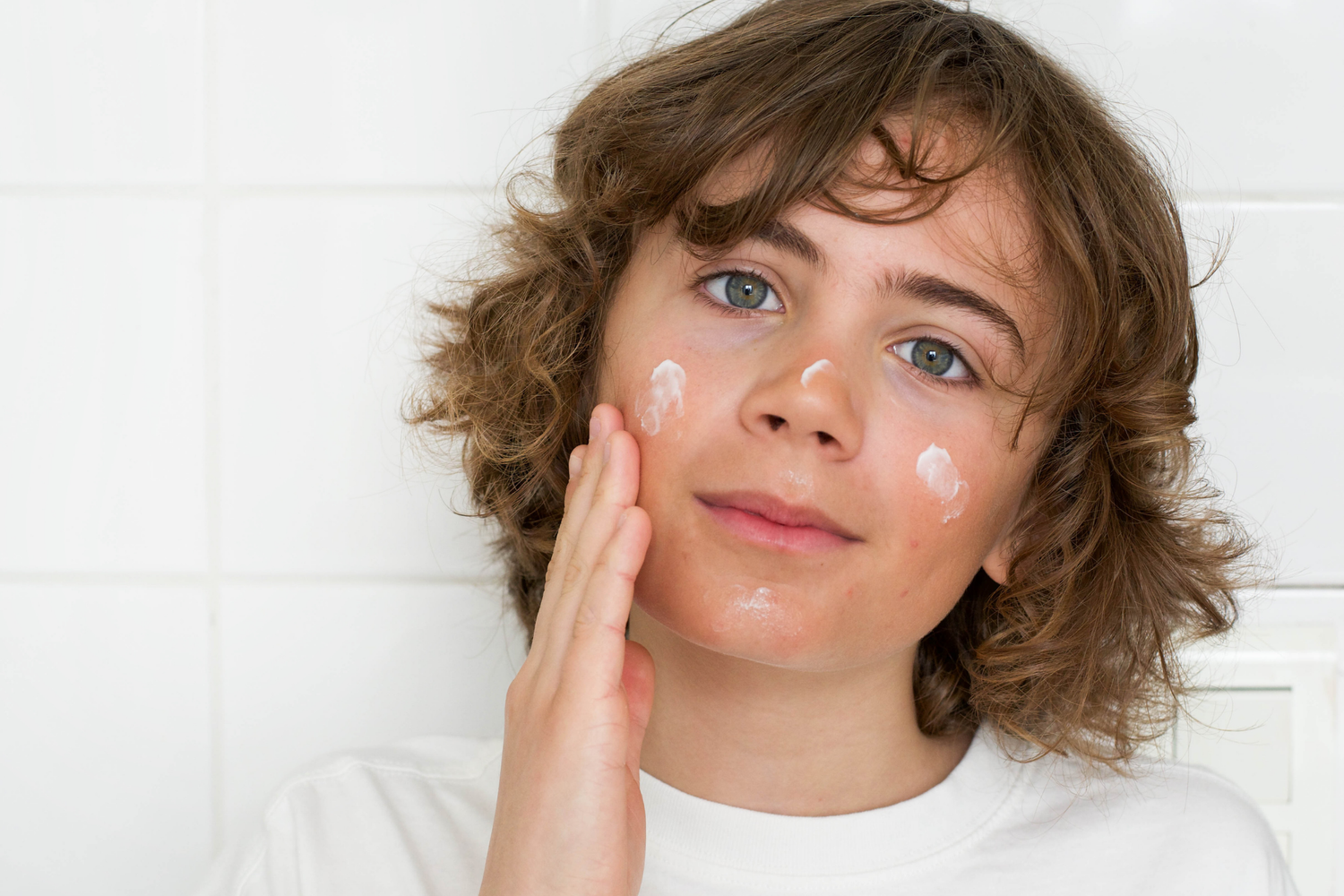 Enfant qui applique une crème visage OUATE — routine soin peau enfant